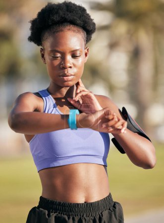 Photo for Fitness, exercise and woman checking her pulse with smartwatch for running outdoor in nature. Sports, workout and African female athlete monitoring heart rate for cardio training for race or marathon. - Royalty Free Image