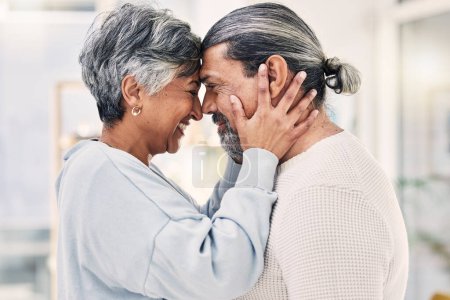 Photo for Hug, forehead and senior couple with love, smile or retirement with happiness, home or loving together. Old woman, happy mature man or embrace in a lounge, quality time or romance with a relationship. - Royalty Free Image