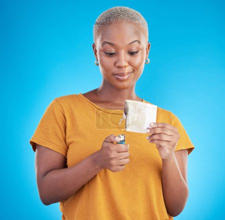 Photo for Woman, burning money and euro bills on fire, flame or financial crisis on studio, blue background and college student. Inflation, increase and banknote of dollar or African customer spending cash. - Royalty Free Image