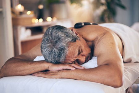 Téléchargez les photos : Homme âgé, dormir et se détendre en massage pour les soins spa, les soins du corps et la physiothérapie à l'hôtel. Calme personne âgée masculine relaxant ou endormi sur le lit de salon pour zen, soulagement du stress ou escapade. - en image libre de droit