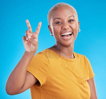 Téléchargez les photos : Portrait de femme main, paix et noir en studio avec remerciements, succès ou retour sur fond bleu. V, signe et visage féminin africain avec de bonnes vibrations, sourire ou liberté emoji ou soutien amour-propre. - en image libre de droit