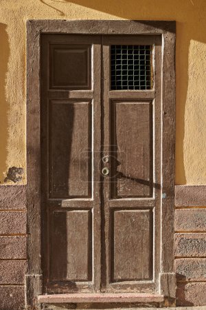 Téléchargez les photos : Structure architecturale altérée et endommagée avec motif rustique vieilli et cadre sur une entrée ou une porte en Espagne. Une vieille porte vintage en bois d'un ancien bâtiment à Santa Cruz de La Palma - en image libre de droit