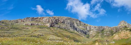 Foto de Vista panorámica del paisaje de Table Mountain en Ciudad del Cabo, Sudáfrica. Bajo paisaje panorámico de un popular punto de referencia natural y atracción turística durante el día contra un cielo azul nublado en verano. - Imagen libre de derechos
