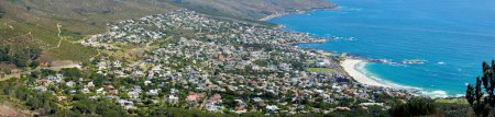 Photo for Panoramic landscape of a large city on the coast from above. Beautiful scenic and aerial view of a popular tourist town or residential area with greenery and the ocean in nature during summer. - Royalty Free Image