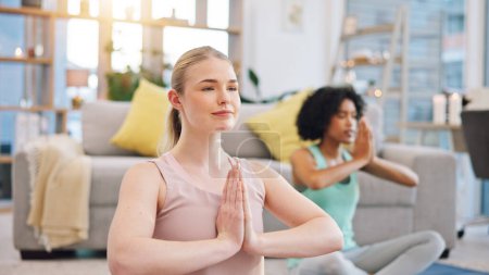 Téléchargez les photos : Yoga, méditation et les femmes à la maison ensemble, fitness et entraînement de pleine conscience dans le salon. Équilibre, respiration et entraînement, amis dans l'exercice holistique dans la paix et zen pour la santé dans l'appartement - en image libre de droit