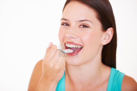 Photo for Eating, yogurt and portrait of woman with healthy food, diet or nutrition in studio with happiness. Happy, face and girl with spoon, yoghurt or strawberry flavor of dairy for breakfast calcium snack. - Royalty Free Image