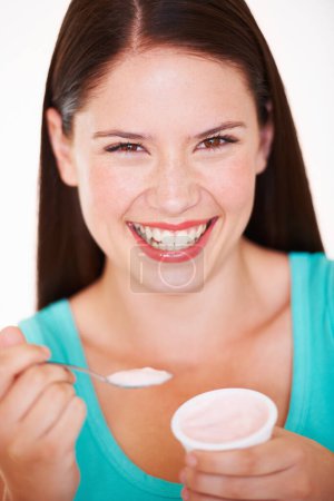 Photo for Woman, eating and portrait with yogurt or healthy food, diet or nutrition in studio with happiness. Happy, face and girl with spoon, yoghurt and strawberry flavor of dairy, product or snack for lunch. - Royalty Free Image