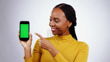 Photo for Woman, phone and green screen for presentation mockup, marketing and happy news on a white background. Young african person on mobile app, space and opportunity with tracking marker in studio. - Royalty Free Image