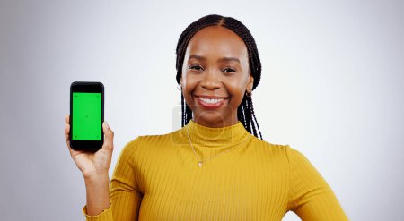 Photo for Happy woman, phone and green screen of marketing mockup, online presentation or news on white background. Portrait of african person on mobile app, website design space and tracking markers in studio. - Royalty Free Image