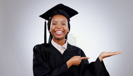 Photo for Graduate, black woman and portrait with pointing to college deal and academy promotion in studio. Happy, university student and school marketing with white background and African person with study. - Royalty Free Image