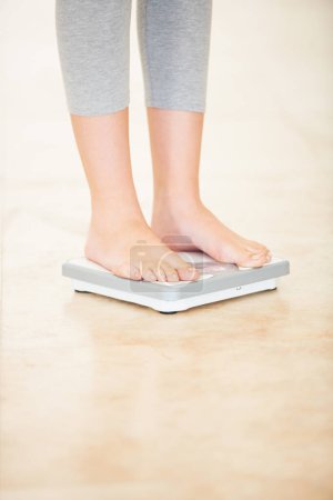 Photo for Woman, weight loss and feet on scale for measurement, goal and control diet for health and wellness. Fitness, scales and person measuring, check and weighing body, mass and electronic device or tech. - Royalty Free Image