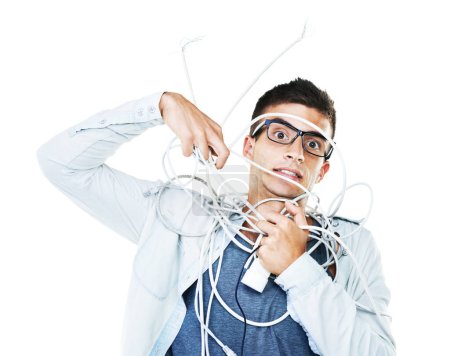 Photo for Portrait of man in glasses tangled in wire, cables and isolated on a white background. Face of serious geek wrapped in cord and tech of nerd or electrician, mistake and problem, chaos or struggle. - Royalty Free Image