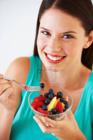 Photo for Health, fruit salad and portrait of woman with berries eating for nutrition, wellness and snack in studio. Food, happy and face of person for vitamins, detox and lose weight on white background. - Royalty Free Image