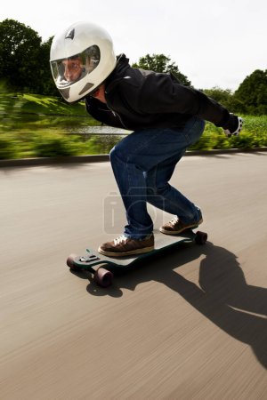 Photo for Man, skateboard and speed with motion blur in street with helmet for exercise, fitness and outdoor in summer. Person, skating and fast in road with thinking for extreme sports, training or moving. - Royalty Free Image