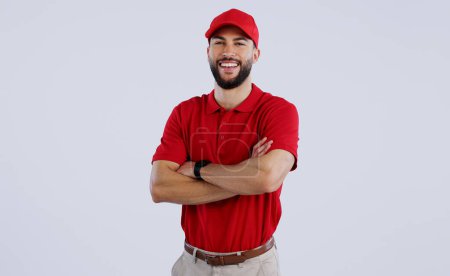 Photo for Happy man, portrait and professional delivery guy with arms crossed in confidence against a gray studio background. Male person, model or courier worker smile with red hat for service on mockup space. - Royalty Free Image