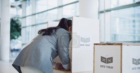 Photo for Vote booth, election and woman at station for politics, freedom in democracy or human rights. Polling, back and person at ballot for choice, equality or decision of government, party or state patriot. - Royalty Free Image