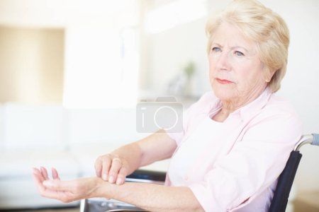 Téléchargez les photos : Femme âgée en fauteuil roulant vérifiant son pouls au poignet. - en image libre de droit