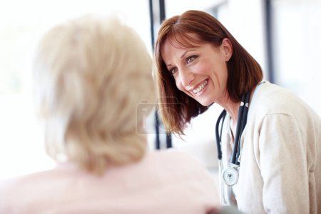 Foto de Un seguimiento amistoso - Cuidado de personas mayores. Enfermera madura tiene una conversación amistosa con una paciente anciana - Imagen libre de derechos