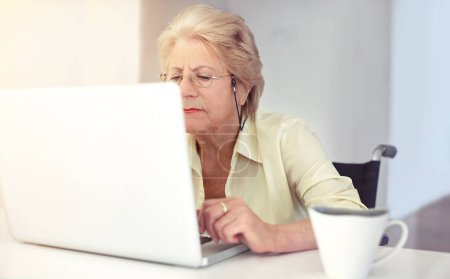 Téléchargez les photos : C'est une vieille technicienne. une femme âgée utilisant son ordinateur portable à la maison - en image libre de droit