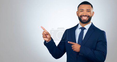 Photo for Portrait, pointing and corporate businessman in studio with smile, deal announcement and mockup space. News, advice and happy man with choice, presentation or offer notification on white background - Royalty Free Image