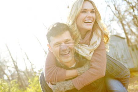 Foto de Esto es tan divertido. Un hombre feliz acariciando a su novia mientras pasa tiempo en el bosque - Imagen libre de derechos