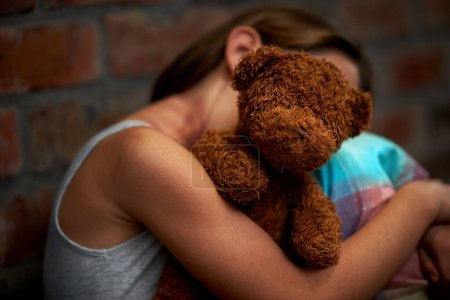 Photo for Abuse, girl and child with fear, teddy bear and stress with depression, anxiety and bullying. Person, kid and victim with a toy, home and sad with mental health, crisis and trauma with development. - Royalty Free Image