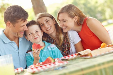 Téléchargez les photos : Joyeux pique-nique familial dans le parc. Heureuse famille attrayante ayant un pique-nique dans le parc - en image libre de droit