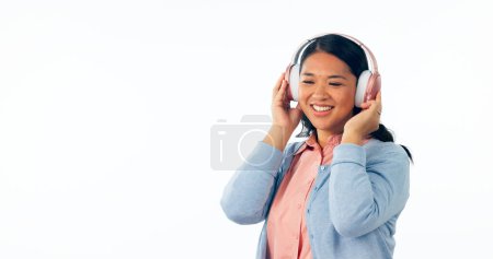 Photo for Headphones, happy or woman in listening to music, playlist or podcast for entertainment. Smile, asian female and relax to stream a song, online radio subscription and technology by white background. - Royalty Free Image