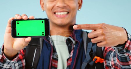 Photo for Hands, point and phone with green screen in studio for hiking app, travel mockup and space by blue background. Person, smartphone and chromakey with tracking markers, promotion and user experience. - Royalty Free Image