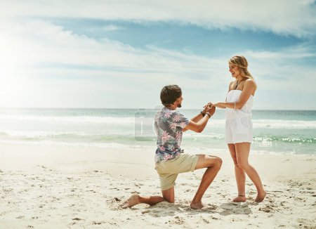 Foto de Quiero pasar el resto de mi vida contigo. Largometraje de un joven proponiéndole matrimonio a su novia en la playa - Imagen libre de derechos