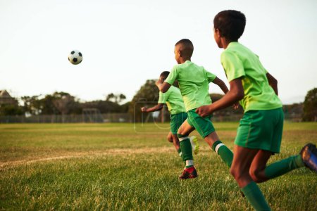 Foto de El fútbol es un excelente ejercicio para los niños. un grupo de jóvenes jugando al fútbol en un campo de deportes - Imagen libre de derechos