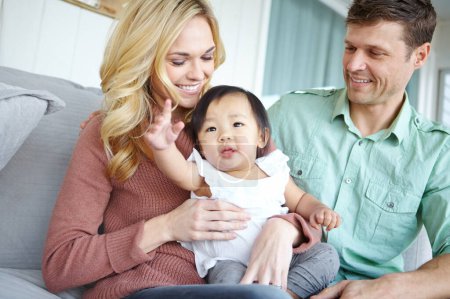 Photo for Adoption Making dreams come true. A happy couple spending time with their beautiful adopted daughter while at home - Royalty Free Image