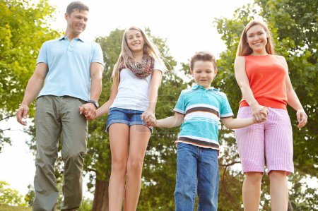 Téléchargez les photos : Passer du temps ensemble dans le parc. une famille heureuse marchant dans le parc - en image libre de droit