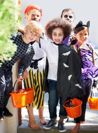 Photo for Our pales are full of candy. Portrait of a group of little children trick-or-treating on halloween - Royalty Free Image