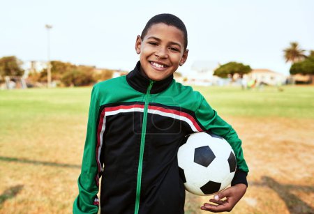 Foto de Tienes que jugar con tus pies y tu corazón. Retrato de un niño jugando al fútbol en un campo de deportes - Imagen libre de derechos
