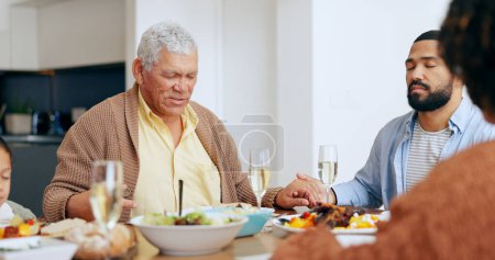 Photo for Food, thanksgiving and a family praying at the dinner table of their home together for eating a celebration meal. Love, holidays and a group of people saying grace for health, diet or nutrition. - Royalty Free Image