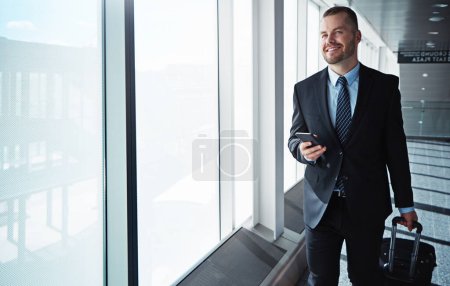 Photo for Business man, smartphone and window in airport hallway with smile, thinking and vision on international travel. Entrepreneur, luggage and phone with flight schedule for global immigration in London. - Royalty Free Image
