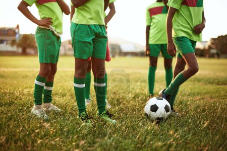 Foto de Empezando con un partido amistoso. Primer plano de un grupo de jóvenes jugando al fútbol en un campo de deportes - Imagen libre de derechos