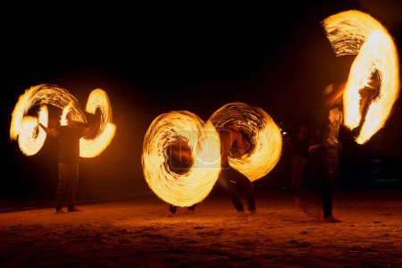 Photo for Fire three ways. a fire performance on a beach in Thailand - Royalty Free Image