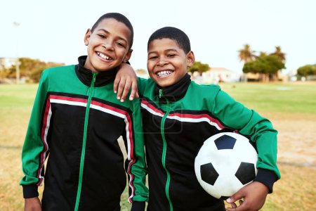Foto de Cuando necesitas un amigo, siempre puedes contar con tus compañeros de equipo. Retrato de dos jóvenes jugando al fútbol en un campo de deportes - Imagen libre de derechos