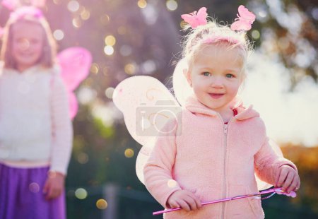 Photo for Of course I can make magic - Im a fairy. Portrait of an adorable little girl dressed up as a fairy and having fun outside - Royalty Free Image