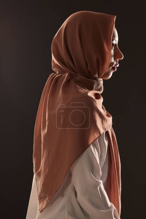 Photo for Muslim woman, profile and hijab in faith for religion, islam or praise against a dark studio background. Side view of Islamic female person or model with scarf in fashion for culture or tradition. - Royalty Free Image