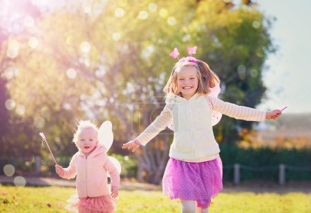 Photo for Make way for the fairies fluttering by. Portrait of two little sisters dressed up as fairies and having fun outside - Royalty Free Image