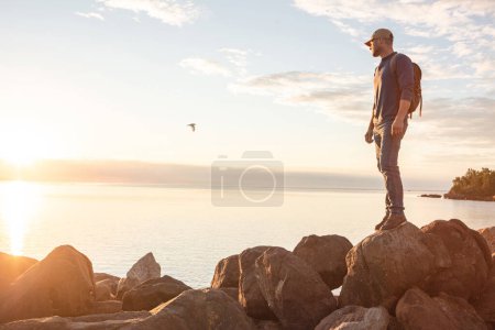 Foto de Las hermosas vistas es lo que más me gusta del senderismo. un hombre mirando al océano mientras hace senderismo - Imagen libre de derechos