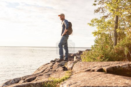 Photo for With each new excursion you will discover beautiful landscapes. a man wearing his backpack while out for a hike on a coastal trail - Royalty Free Image