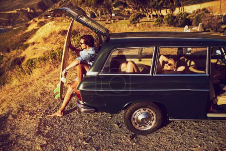 Foto de Ve a ver qué hay ahí fuera. una joven pareja relajándose en su coche durante un viaje en carretera - Imagen libre de derechos