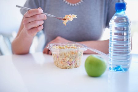 Photo for Hand, fork and employee eating food in the cafeteria on a lunch break for health, diet or nutrition closeup. Water, apple and noodle salad with a business person in the office for a meal or snack. - Royalty Free Image