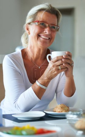 Photo for Mature, woman and coffee smile at breakfast for retirement relax or happy home bread snack, espresso for rest. Female person, hot drink and beverage cup meal or muffin for hungry, eating on holiday. - Royalty Free Image