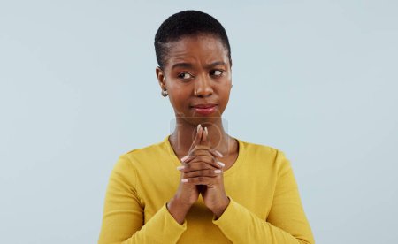 Photo for Doubt, wish and thinking, black woman in studio with hope for opportunity, deal or good news prayer. Hands together, emoji and person with ideas, offer and faith on white background with confusion - Royalty Free Image