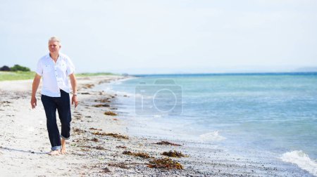 Photo for Beach, walking and senior man on a travel tropical vacation, holiday or weekend trip in summer. Adventure, outdoor and elderly male person in retirement on the sand by the ocean or sea on getaway - Royalty Free Image